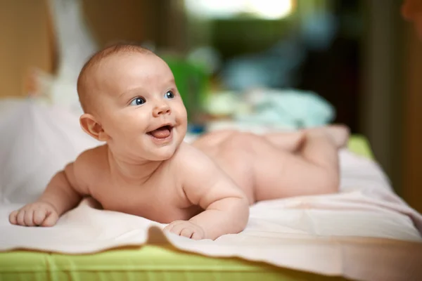Cheerful child lying on changing table — Stok fotoğraf