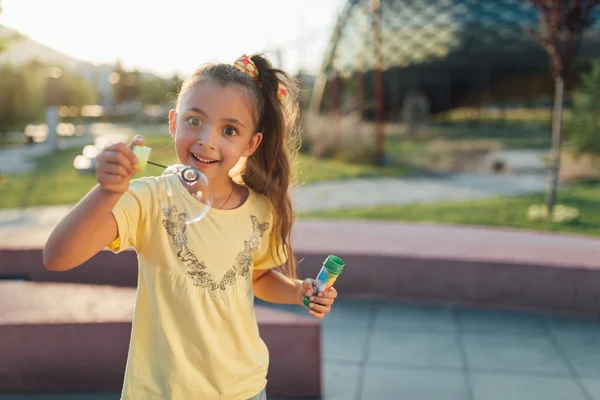Маленька дівчинка дивиться на бульбашку і посміхається — стокове фото