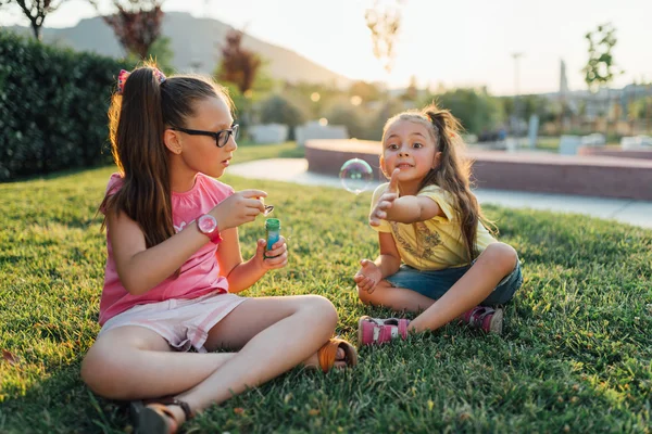 Deux filles sont assises sur l'herbe — Photo