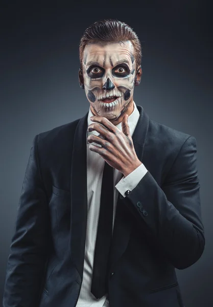 Удивленный бизнесмен с гримерным скелетом — стоковое фото