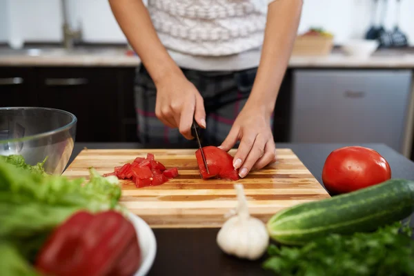 Mädchen hackt Tomaten auf Salat — Stockfoto