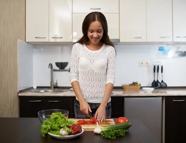 Felice ragazza in cucina taglio insalata — Foto Stock