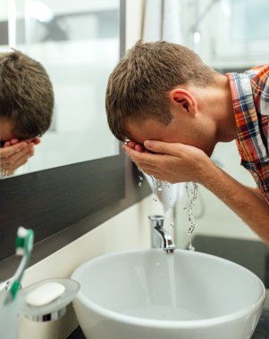 adam yüzüne sprey ile yıkar