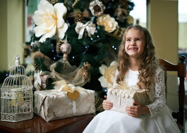 Aranyos fogatlan lány örül a karácsonyi ajándék — Stock Fotó