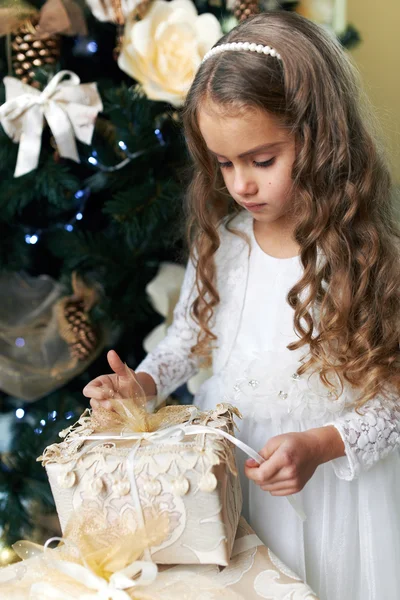 Beautiful girl opens   gift for the new year — Stock Photo, Image