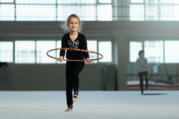 Jente som lærer å bruke bøyle i rytmisk gymnastikk . – stockfoto