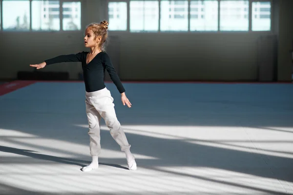 Menina praticando ginástica rítmica no ginásio — Fotografia de Stock