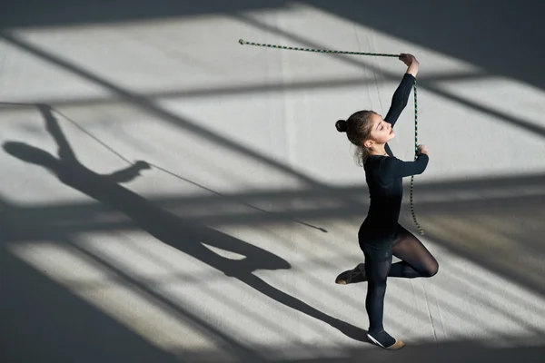 Menina exercitando com corda na ginástica rítmica — Fotografia de Stock