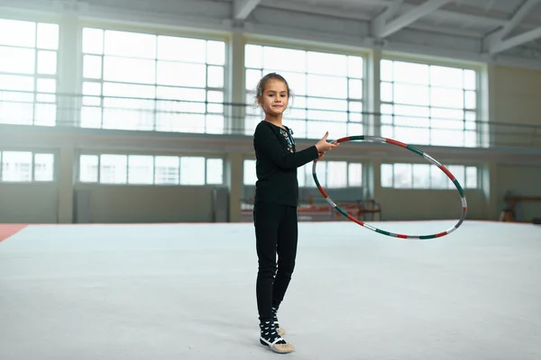 Chica aprendiendo a usar aro en gimnasia rítmica . — Foto de Stock