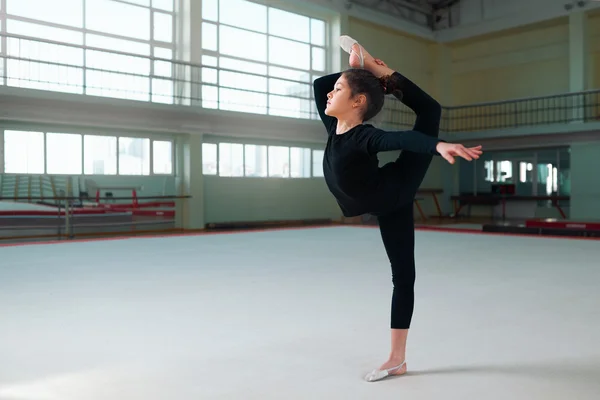 Egzersizleri yapıyor bir eşofman kız jimnastikçi — Stok fotoğraf