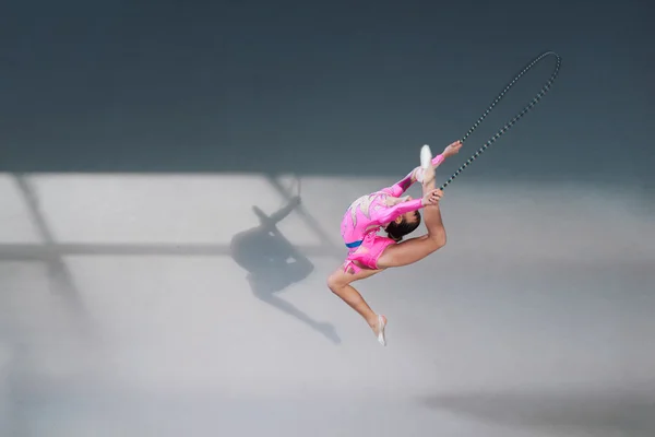 Vista lateral da ginasta em vestido com corda de salto — Fotografia de Stock