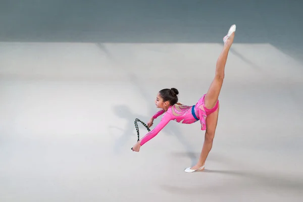 Gimnastyczka w kolorze robi ćwiczenia z skakanka — Zdjęcie stockowe