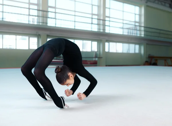 Гімнастка в чорному костюмі робить сорочку — стокове фото