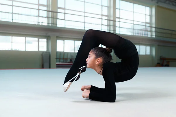 Gymnast voert een terug bocht op verdieping — Stockfoto