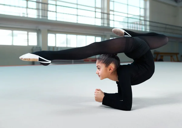 Niña practicando gimnasia en gimnasio-hall — Foto de Stock