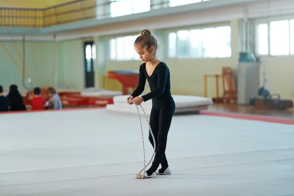Девушка тренируется с веревкой по художественной гимнастике . — стоковое фото