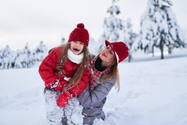 Anne kızıyla karlı kış parkta birlikte yürür