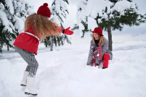 Hija y madre jugando con la nieve —  Fotos de Stock