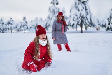 Anne kızıyla karlı kış parkta birlikte yürür