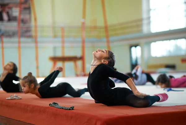 Sie knetet sich im Training rhythmische Gymnastik zurück — Stockfoto