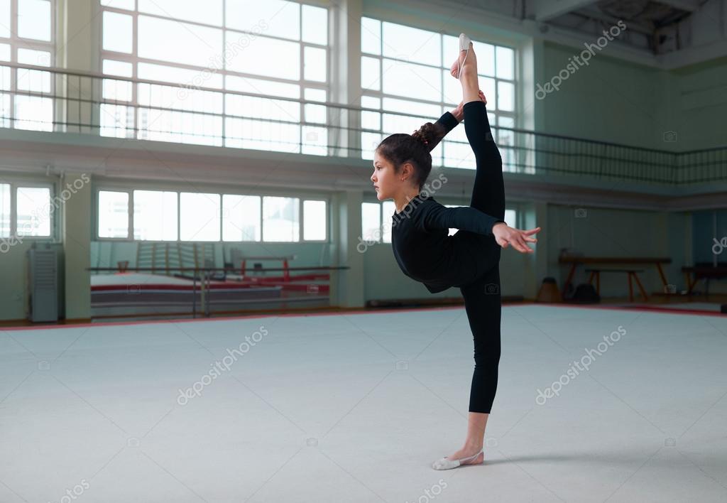 girl gymnast in a sweatsuit doing exercises 