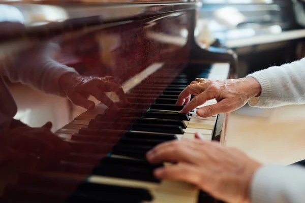Experimentado manos viejas primer plano tocando el piano — Foto de Stock