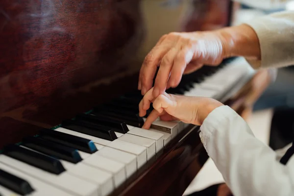 Mão de um pianista experiente ajudando jovens estudantes — Fotografia de Stock