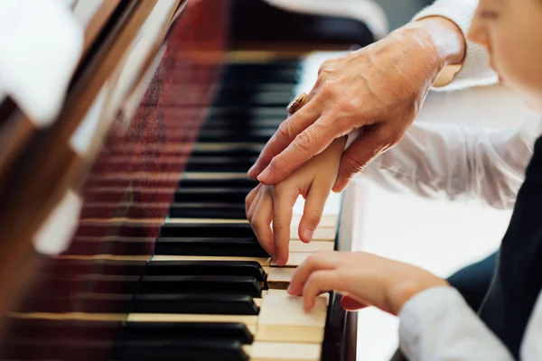 Mano de un pianista experimentado ayudando a jóvenes estudiantes — Foto de Stock