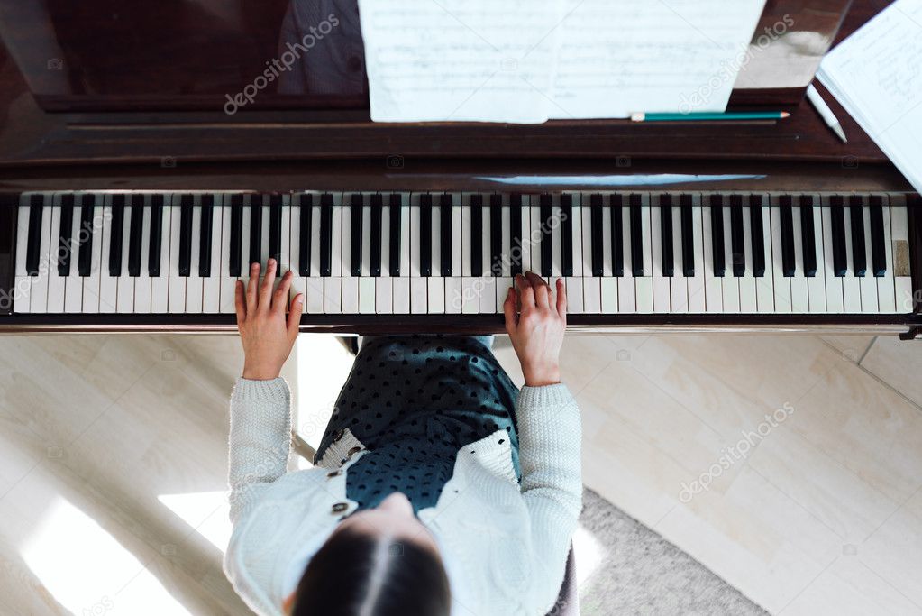 girl playing on  grand piano, top view