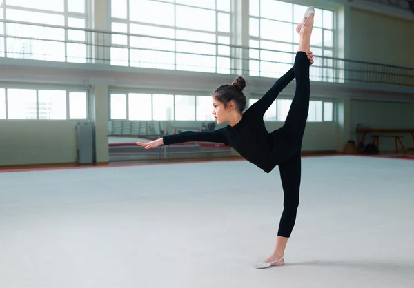 Дівчина гімнастка в костюмі робить вправи — стокове фото