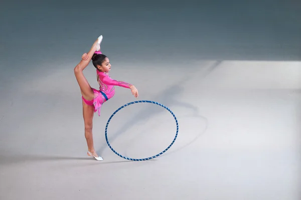 Gimnasta en un hermoso traje haciendo ejercicio de aro — Foto de Stock