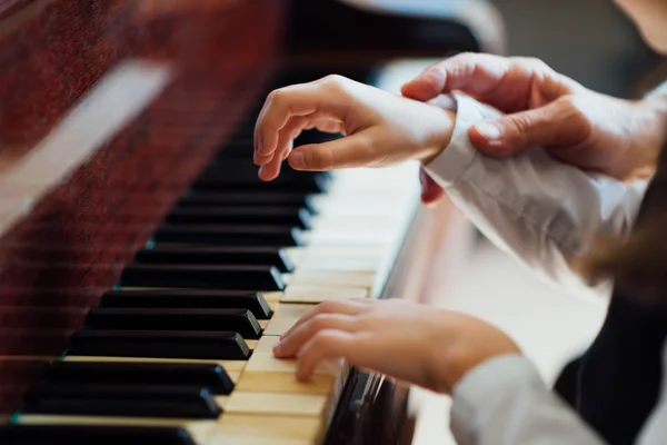 Experienced master piano hand helps the student — Stock Photo, Image