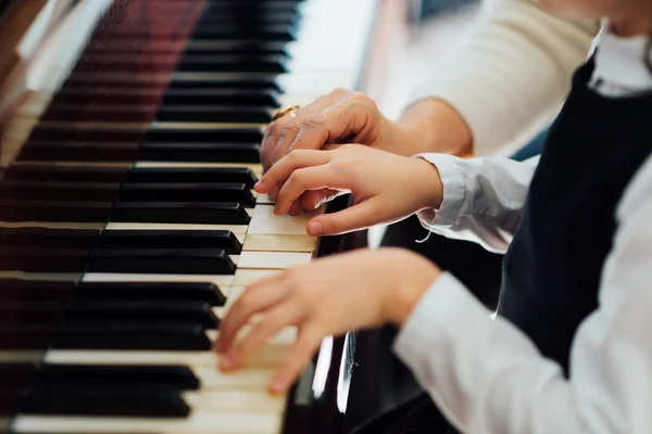 Experiente mestre mão piano ajuda o aluno — Fotografia de Stock