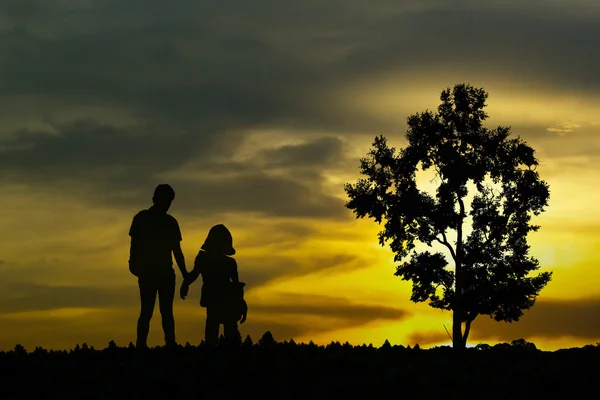 日没時に海岸に沿って歩く若いカップルのビュー — ストック写真