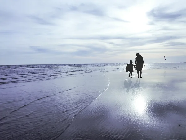 La silueta de la familia observando el amanecer en la playa — Foto de Stock