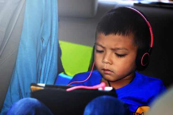 可爱的小男孩，听音乐耳机与平板电脑出局 — 图库照片