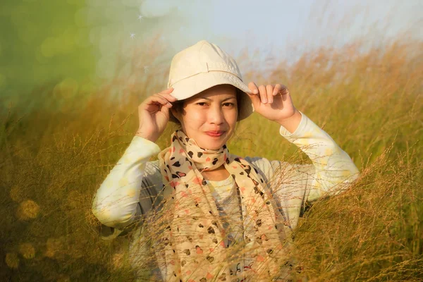 Jovem mulher está de pé no prado com os braços levantados desfrutando de sol — Fotografia de Stock