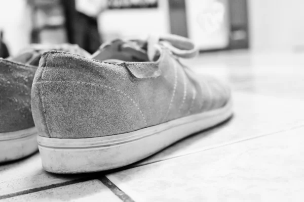 Gamle sko på skitten bakgrunn bearbeidet i grunge-stil – stockfoto
