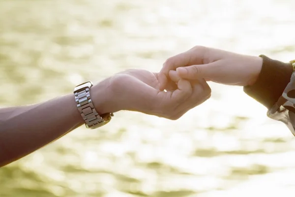 Jong paar in liefde hand in hand op zoek in de zonsondergang — Stockfoto