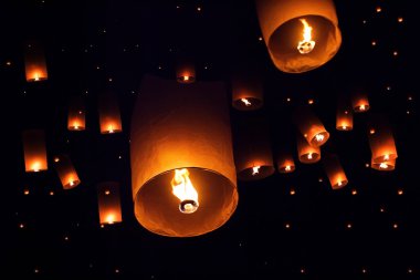 People launch sky lanterns to the sky in Loy Kratong festival clipart