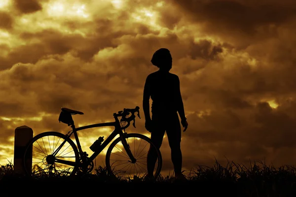 Stand uomo su Mountain bike silhouette in sunris — Foto Stock