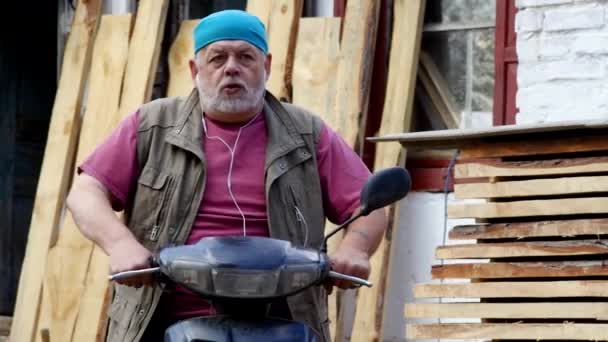 Kaukasischer Bärtiger Senior Auf Moped Zeigt Mit Ausdrucksstarkem Gesicht Und — Stockvideo