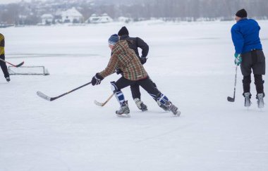 Dnipro, Ukrayna - 28 Ocak 2018: Ukrayna 'da donmuş bir nehirde hokey oynayan bir grup farklı yaşlı insan