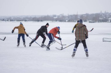 Dnipro, Ukrayna - 28 Ocak 2018: Ukrayna 'da donmuş bir nehirde hokey oynayan aktif farklı yaş ve cinsiyet grupları