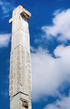 Mavi gökyüzü geri üzerinde terk edilmiş inşaat sahasında beton sütunlar