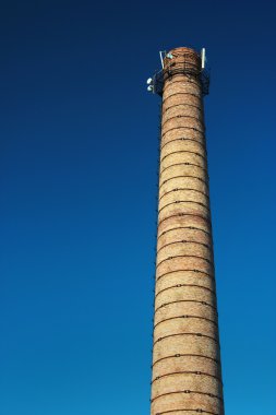 Hücre Yineleyici İstasyon üstünde tepe ile eski tuğla baca