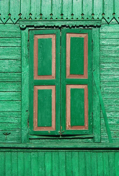 Stará malovaná zelené dřevěné zavírali okno na zdobené zdi — Stock fotografie