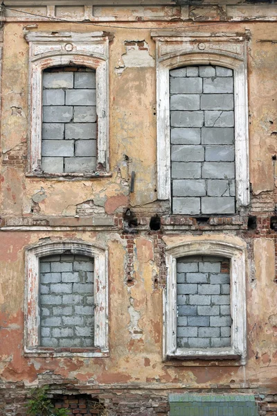 Detalhe da parede antiga e desgastada com janelas cheias de tijolo — Fotografia de Stock