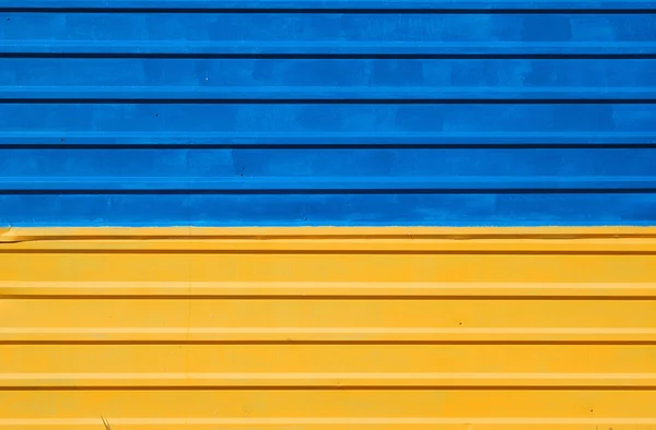 Металлический забор окрашен в цвета украинского флага — стоковое фото