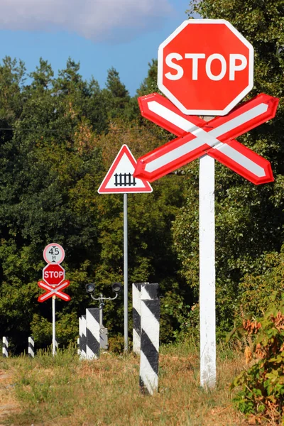 Unguarded railway crossing signs in a rural landscape — Stock Photo, Image